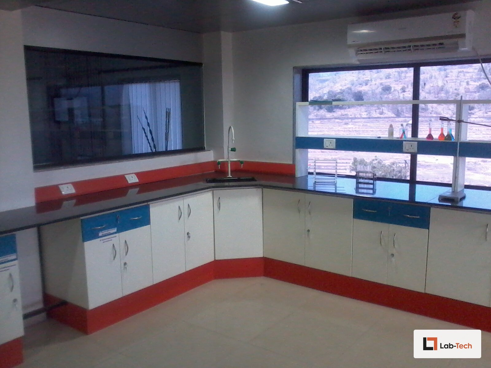 Completed L-shaped Lab-Tech bench run with sink, lab tap, and under-bench cabinets.