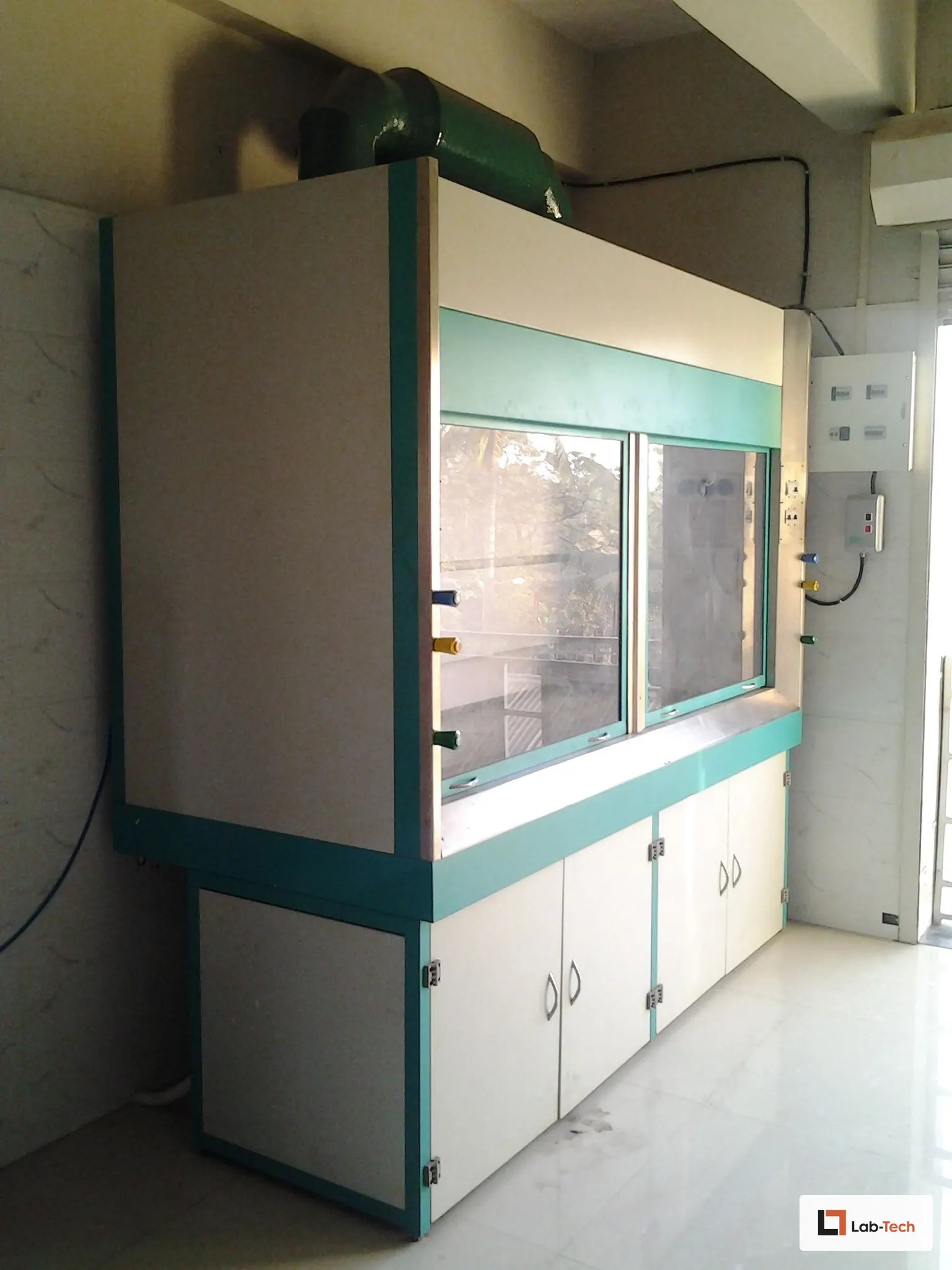 Teal-trim Lab-Tech fume hood with sash raised, ducted to ceiling extraction.